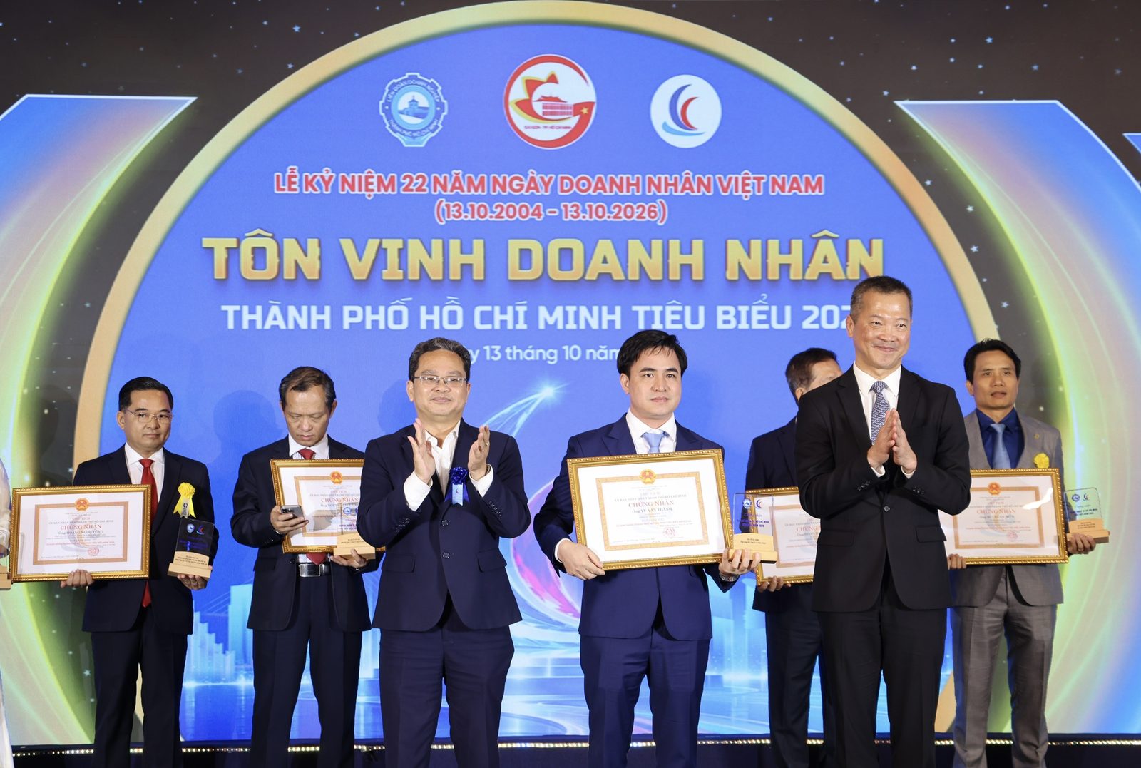 Ông Vũ Văn Thành, Chủ tịch Hội đồng quản trị kiêm Tổng Giám đốc Công ty Cổ phần SPHACY, cầm giấy chứng nhận danh hiệu Doanh nhân Thành phố Hồ Chí Minh tiêu biểu năm 2026 trên sân khấu Lễ kỷ niệm 22 năm Ngày Doanh nhân Việt Nam ngày 13/10/2026